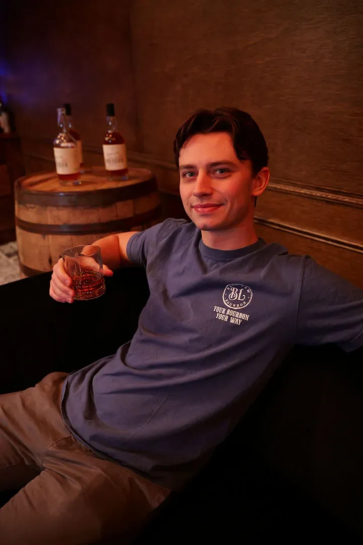 Man in branded tee holding bourbon